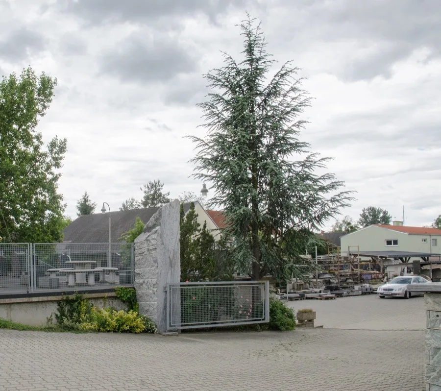 Einfahrt zum Steinmetzbetrieb an der Grazerstraße mit Stein-Monolith, Ausstellungsfläche und Lagerplatz
